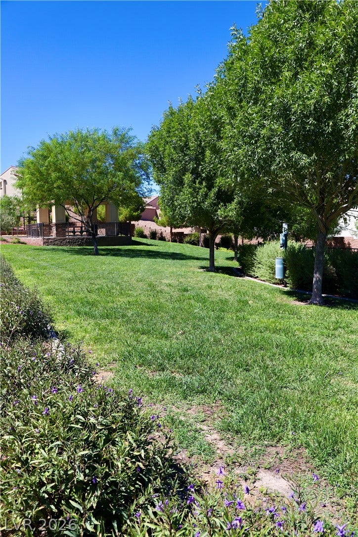 Mature shade trees and manicured lawns frame the community park and pavilion.