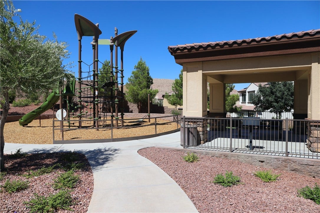 A community play area features structured climbing equipment alongside a sheltered pavilion.
