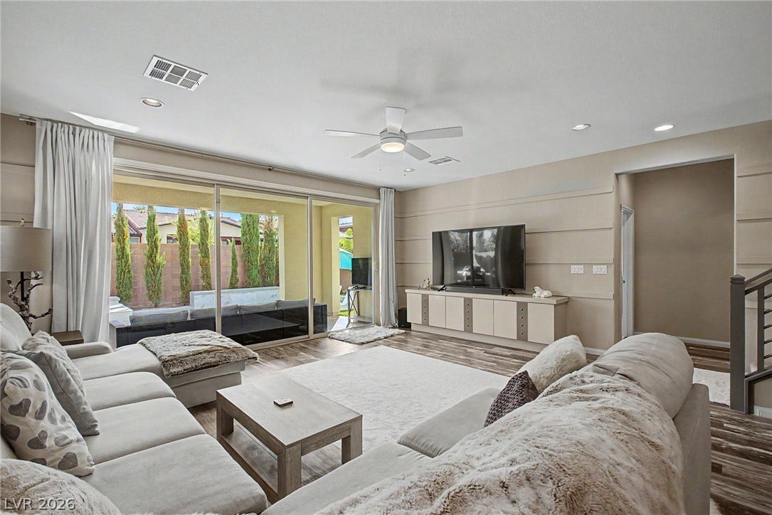 Sliding glass doors frame garden views and fill this comfortable living space with natural light.