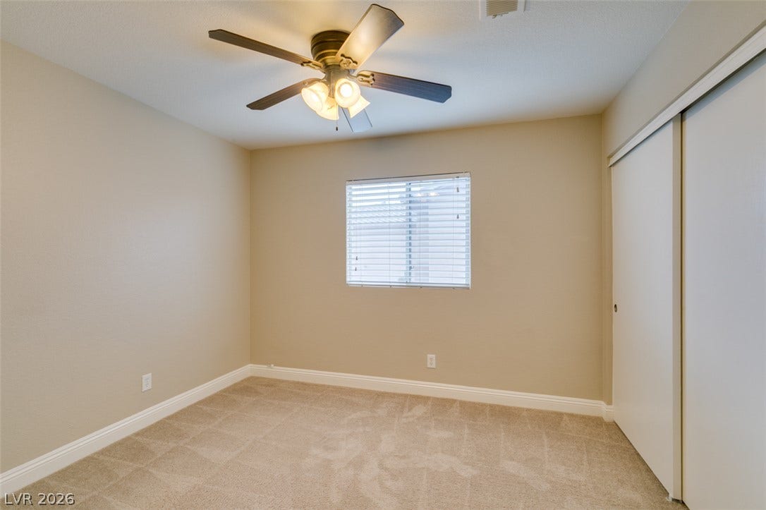 437 Waterwheel Falls Drive, Henderson, NV 89015 2nd Bedroom. Soft carpeting pairs with neutral walls and a wide sliding closet in this comfortable bedroom.