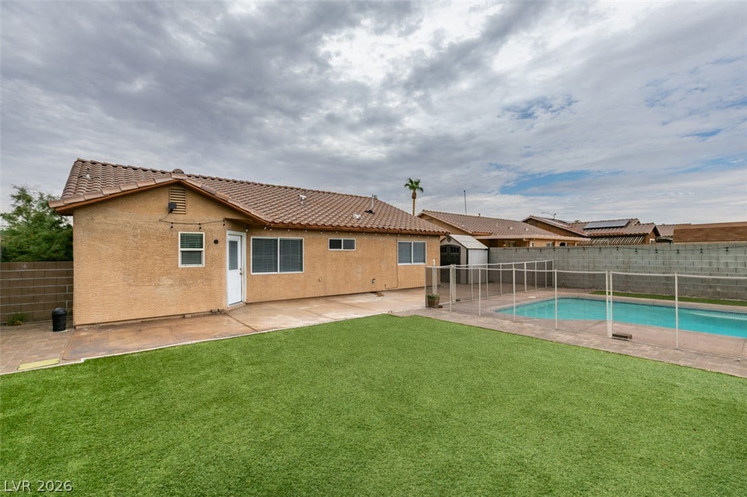 437 Waterwheel Falls Drive, Henderson, NV 89015 View of primary house. A spacious backyard features a private swimming pool set alongside low-maintenance synthetic turf.