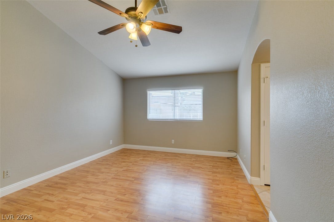 437 Waterwheel Falls Drive, Henderson, NV 89015 High vaulted ceilings and wood-style flooring elevate this versatile bedroom.
