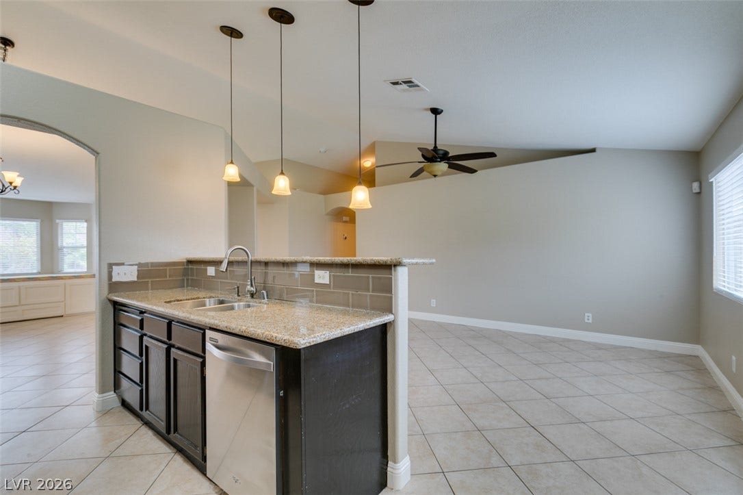 437 Waterwheel Falls Drive, Henderson, NV 89015 Tile flooring and stone counters define this open floorplan space connecting kitchen and living areas.