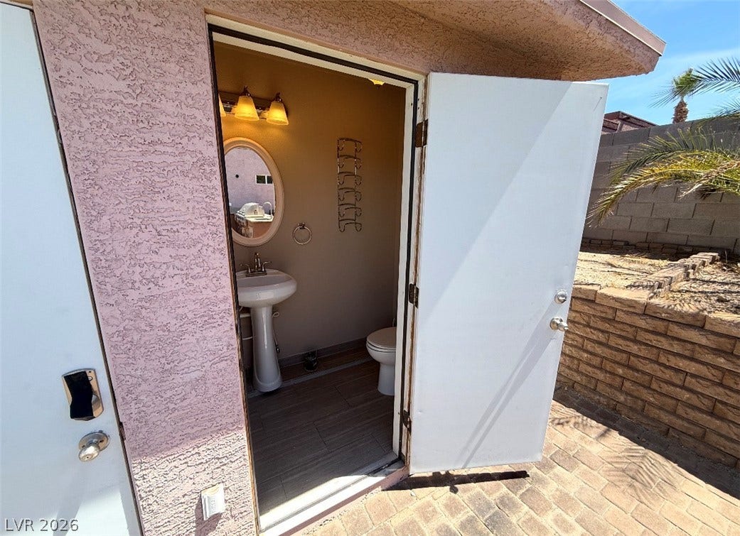 437 Waterwheel Falls Drive, Henderson, NV 89015 An outdoor half bath for pool guests features a pedestal sink and tile flooring near the pool area.
