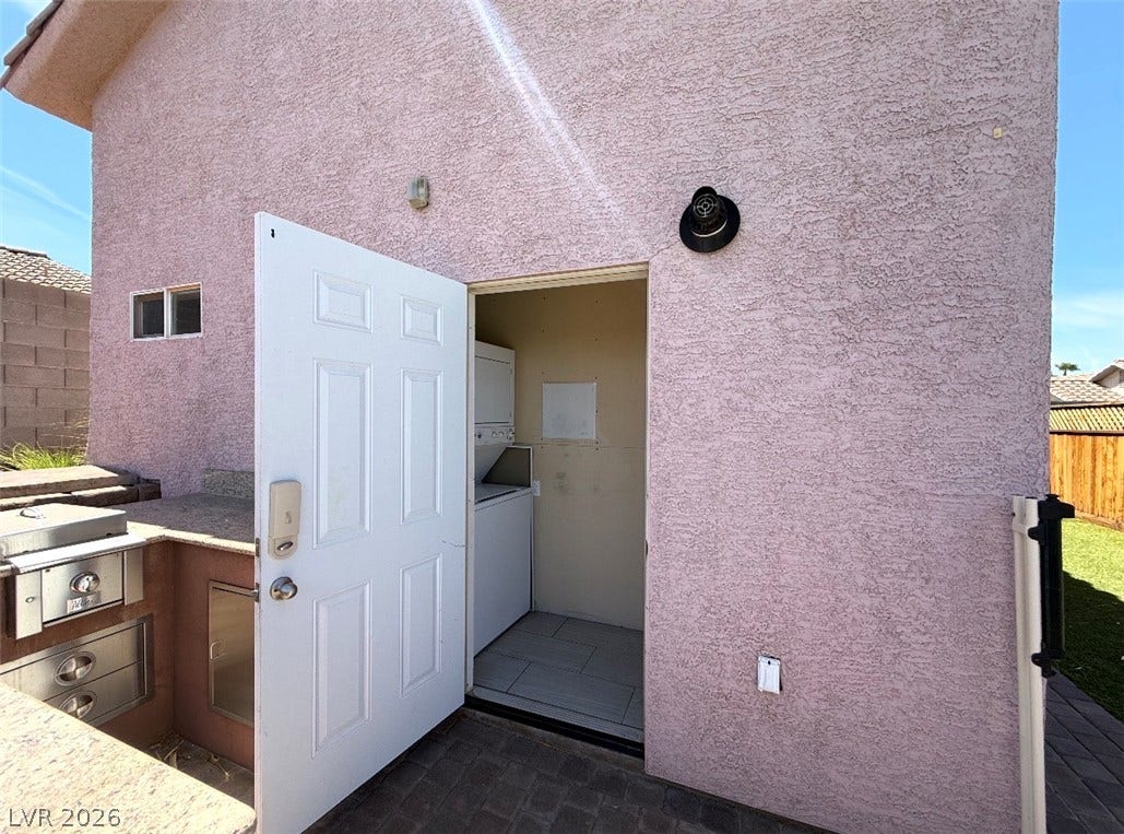 437 Waterwheel Falls Drive, Henderson, NV 89015 Guet house laundry room. An outdoor utility closet opens to reveal a stacked washer and dryer setup near the patio.