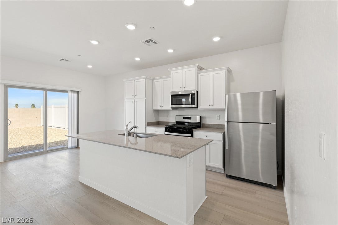 Sliding glass doors open to the backyard from this modern kitchen with a central island.