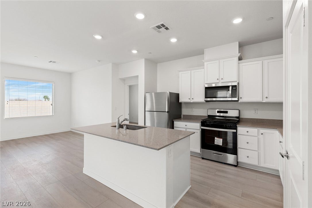 2754 Avril Point Street, Las Vegas, NV 89156 A spacious kitchen features recessed lighting, smooth wood floors, and a functional central island.