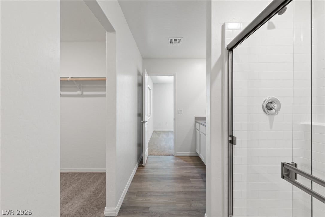 6740 Magnolia River Avenue, Las Vegas, NV 89156 Clean lines and smooth finishes define this modern transition between a bathroom and walk-in closet.