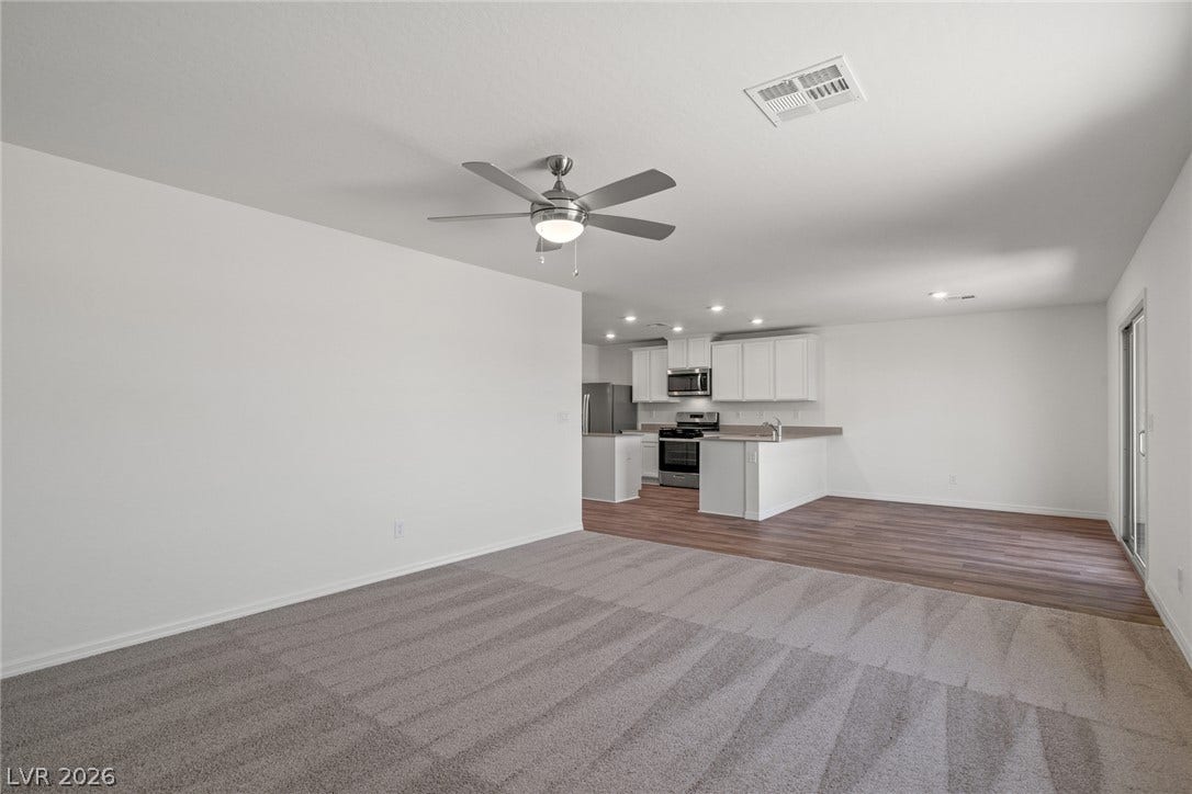 An open floor plan connects the carpeted living space directly to the kitchen.