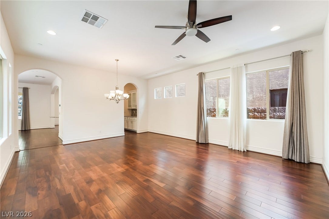72 Rezzonico Drive, Henderson, NV 89011 Rich hardwood flooring anchors this versatile open space featuring clean walls and arched transitions.