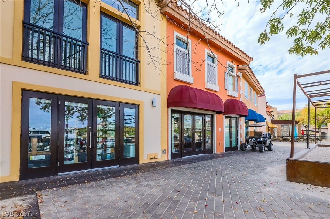 72 Rezzonico Drive, Henderson, NV 89011 Mediterranean-inspired storefronts feature classic clay tile roofing, elegant glass entryways, and paved walkways.