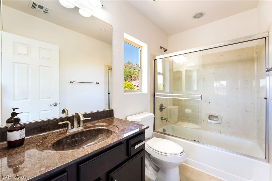 72 Rezzonico Drive, Henderson, NV 89011 A stone counter vanity and glass shower enclosure define this modern bathroom space.