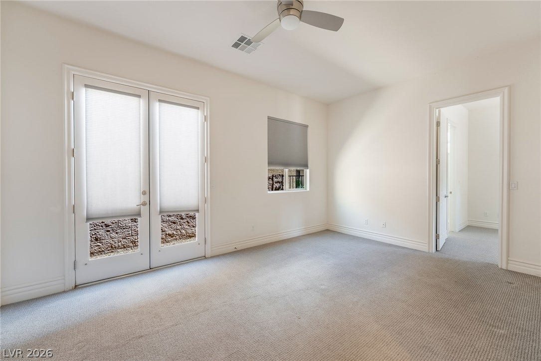 72 Rezzonico Drive, Henderson, NV 89011 Double glass doors open to the outdoors from this carpeted room.