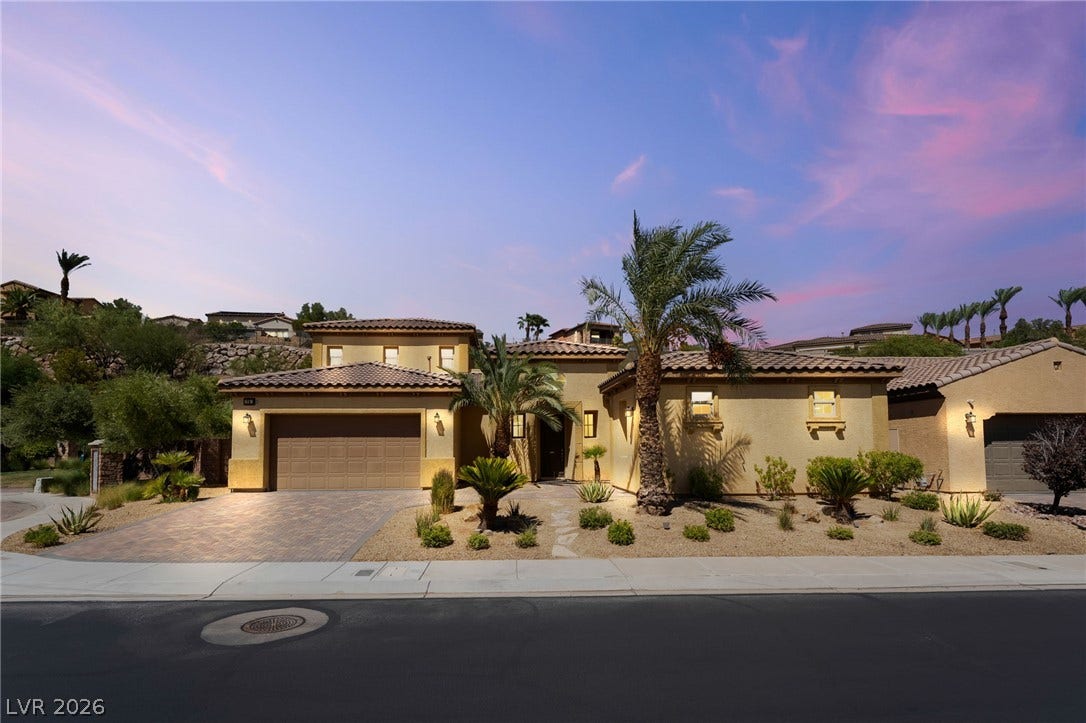 72 Rezzonico Drive, Henderson, NV 89011 Desert landscaping and a paved driveway complement this two-story exterior under a twilight sky.
