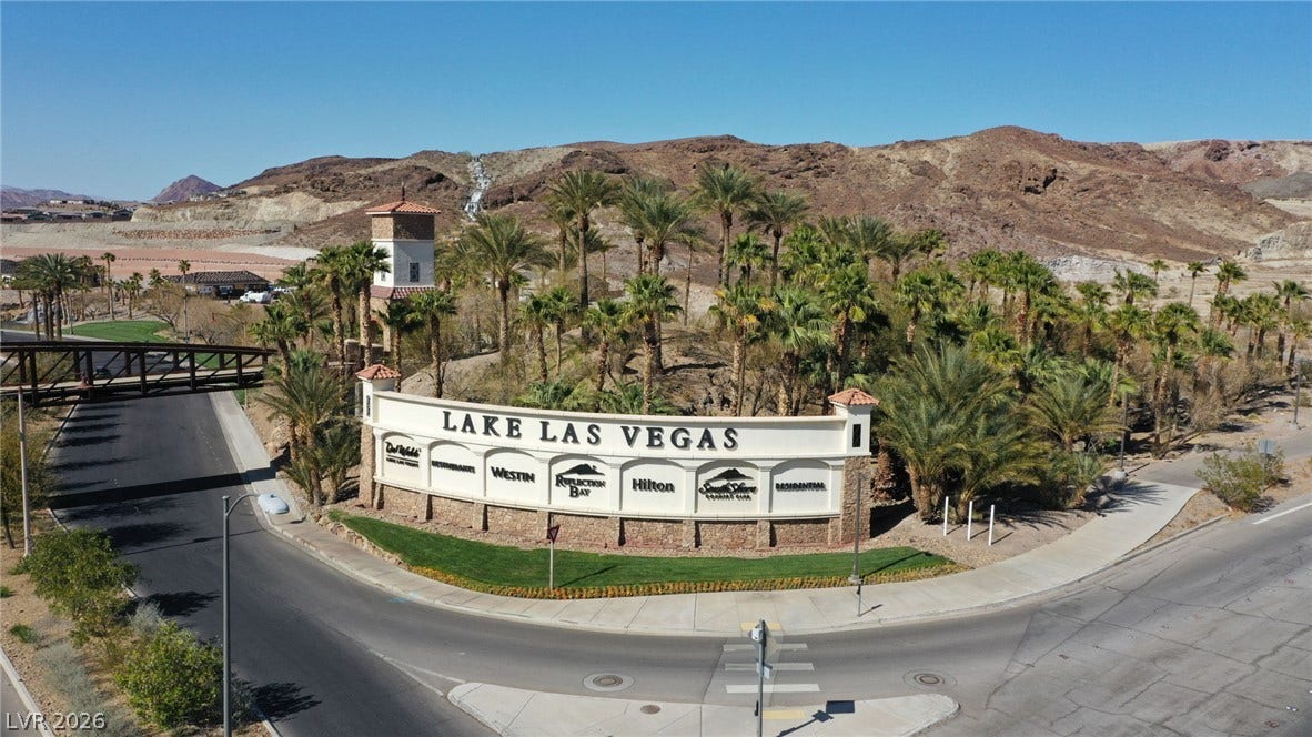 72 Rezzonico Drive, Henderson, NV 89011 Palm trees and rolling desert hills frame the welcoming community entrance sign.