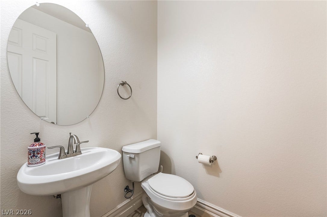 72 Rezzonico Drive, Henderson, NV 89011 A classic pedestal sink pairs with an oval mirror in this clean powder room.