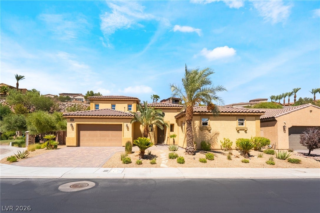 72 Rezzonico Drive, Henderson, NV 89011 Palm trees and desert landscaping frame the elegant stucco exterior of this multi-level home.