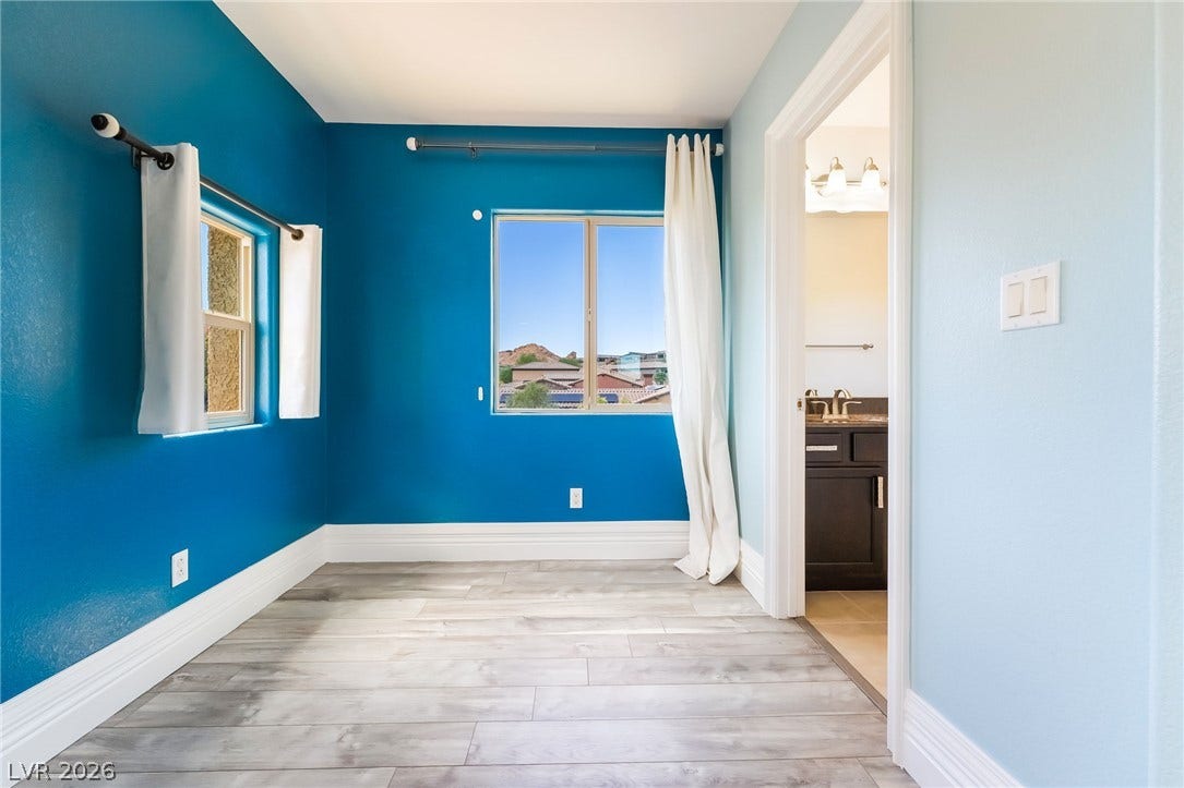 72 Rezzonico Drive, Henderson, NV 89011 Plank flooring and baseboard molding enhance this versatile bedroom space with attached bath access.