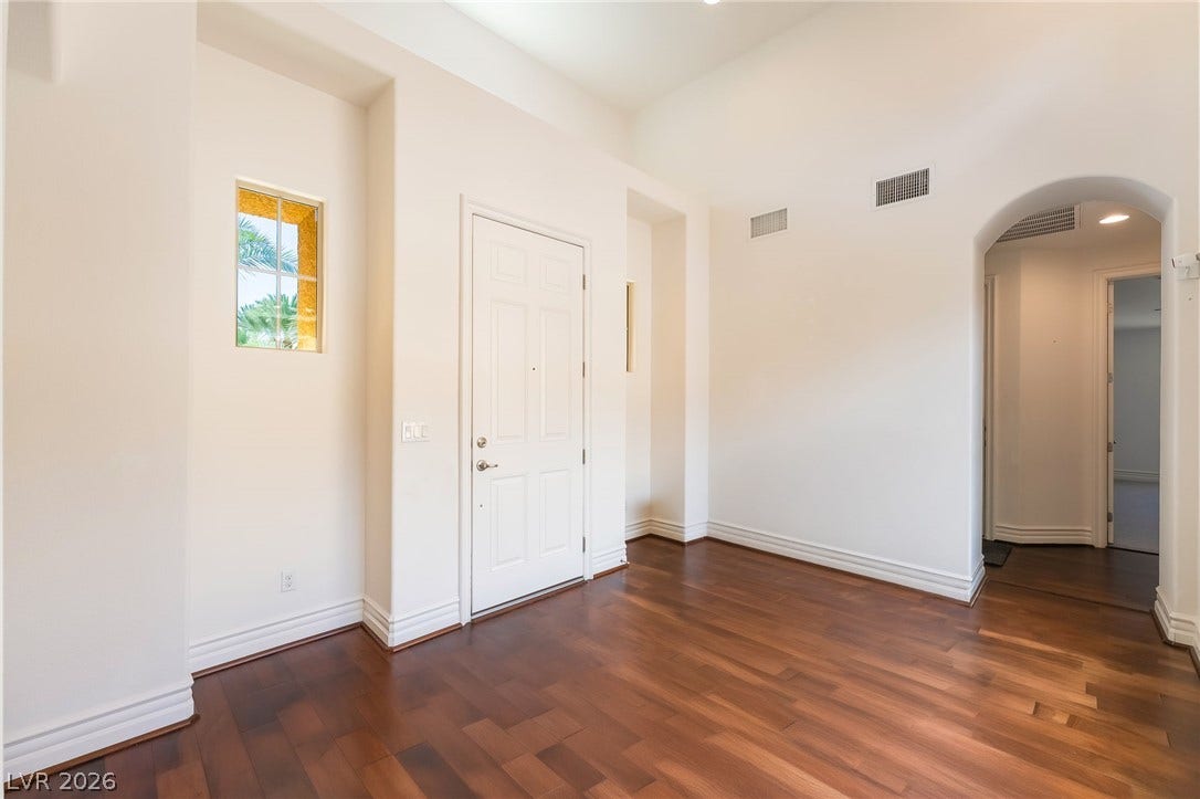 72 Rezzonico Drive, Henderson, NV 89011 Rich wood floors and a soaring ceiling define this welcoming entry hall.