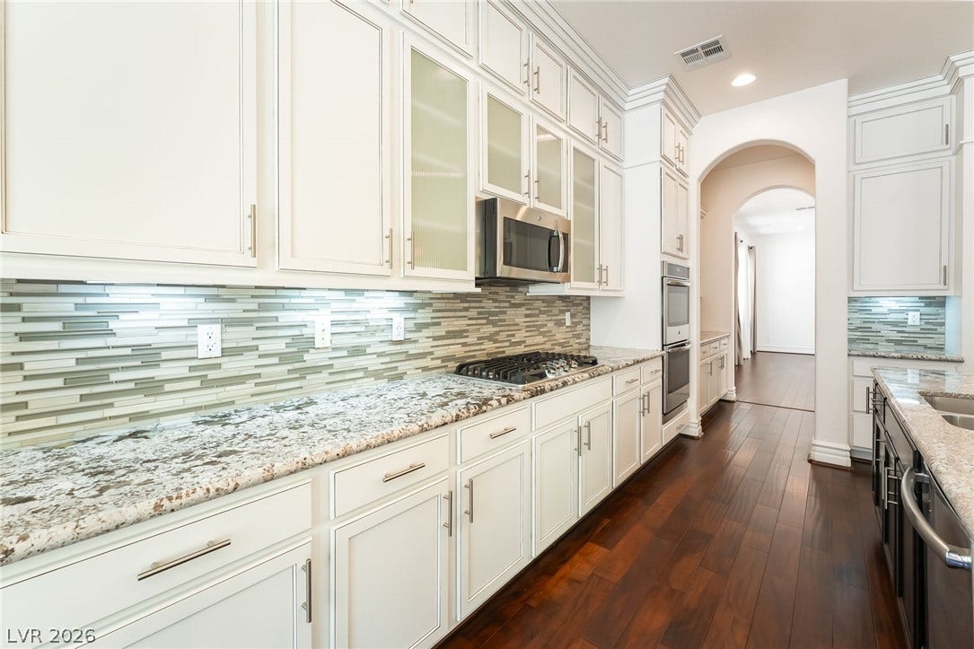 72 Rezzonico Drive, Henderson, NV 89011 Gleaming stone countertops and classic cabinetry line this beautifully designed culinary space.