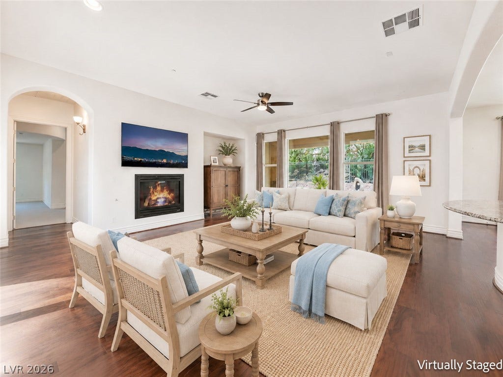72 Rezzonico Drive, Henderson, NV 89011 Virtually Staged. Rich hardwood floors and a modern fireplace anchor this light-filled gathering space.