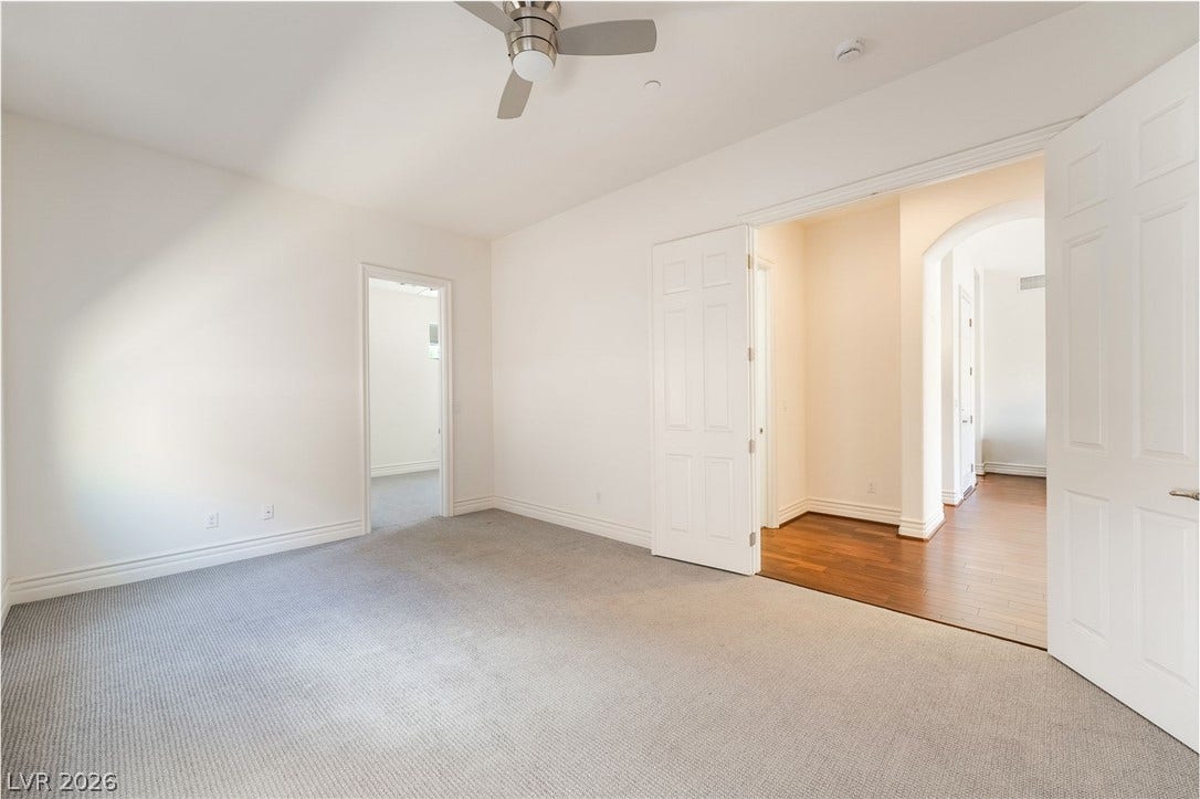 72 Rezzonico Drive, Henderson, NV 89011 Double doors open to a spacious bedroom featuring soft carpeting and high ceilings.