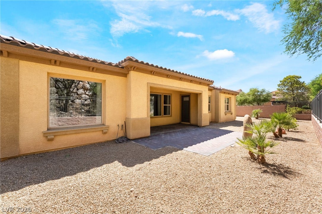 72 Rezzonico Drive, Henderson, NV 89011 An inviting covered patio opens to a low-maintenance desert yard under clear blue skies.