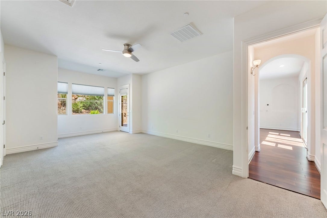 72 Rezzonico Drive, Henderson, NV 89011 Generous proportions and soft carpeting define this versatile living space opening to an adjacent hallway.