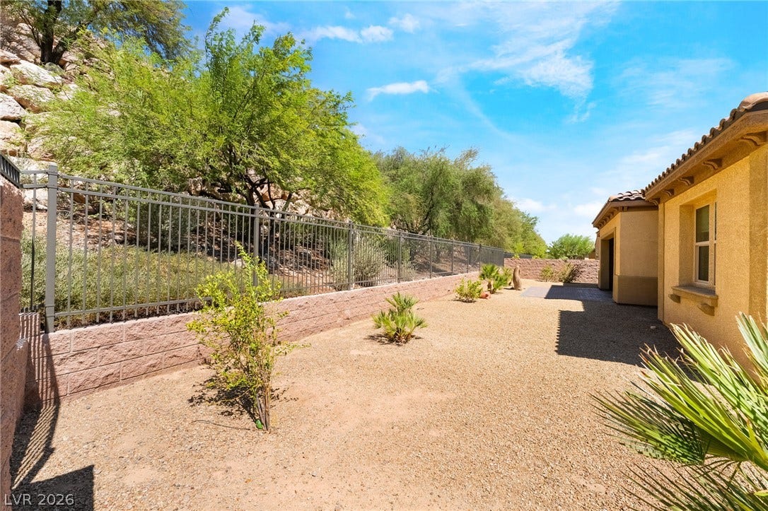 72 Rezzonico Drive, Henderson, NV 89011 Desert landscaping and a secure metal fence define this low-maintenance side yard.
