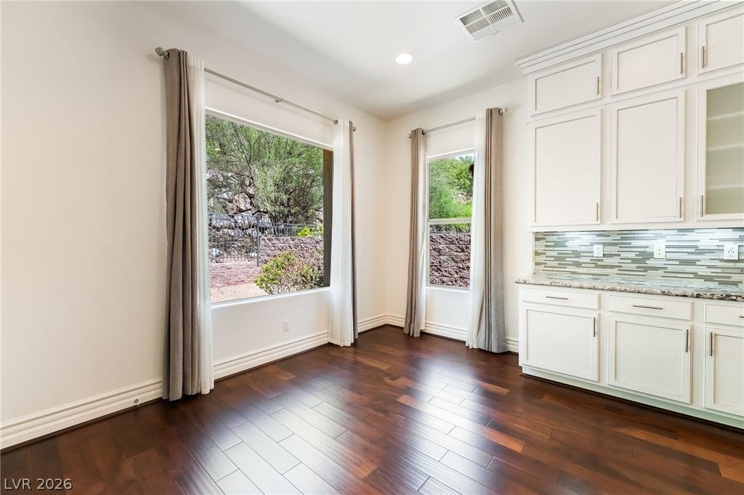 72 Rezzonico Drive, Henderson, NV 89011 Rich hardwood flooring complements custom cabinetry and large windows framing serene desert views.