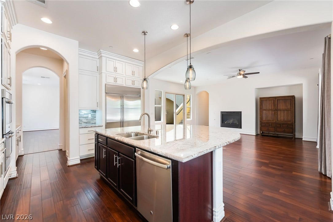 72 Rezzonico Drive, Henderson, NV 89011 Gleaming hardwood floors and a spacious granite-topped island highlight this open-concept kitchen layout.