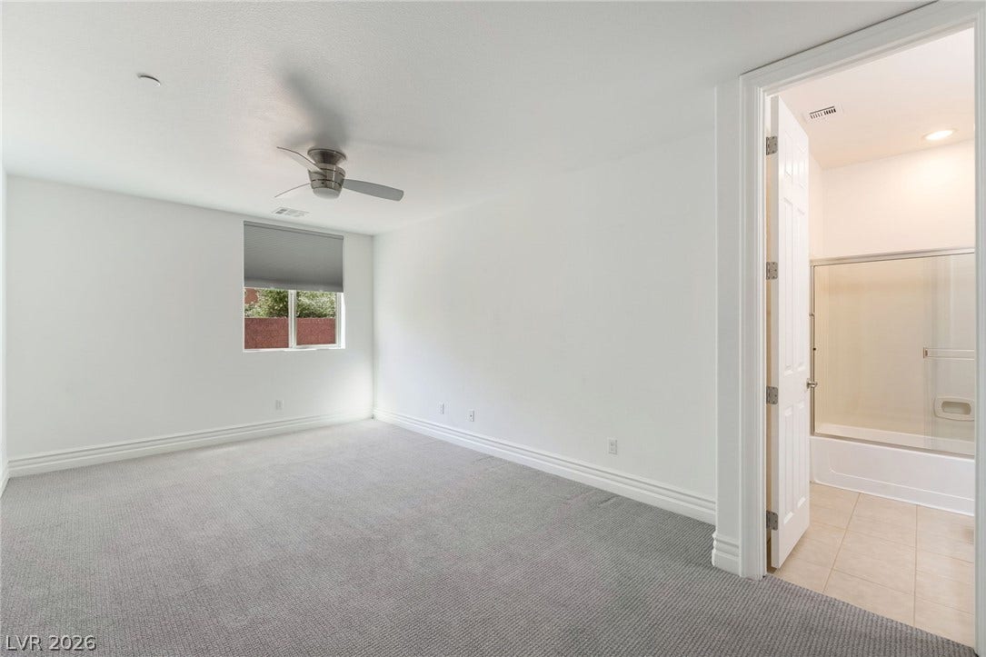 72 Rezzonico Drive, Henderson, NV 89011 Plush carpeting and crisp baseboards highlight this serene secondary suite with adjacent bath access.