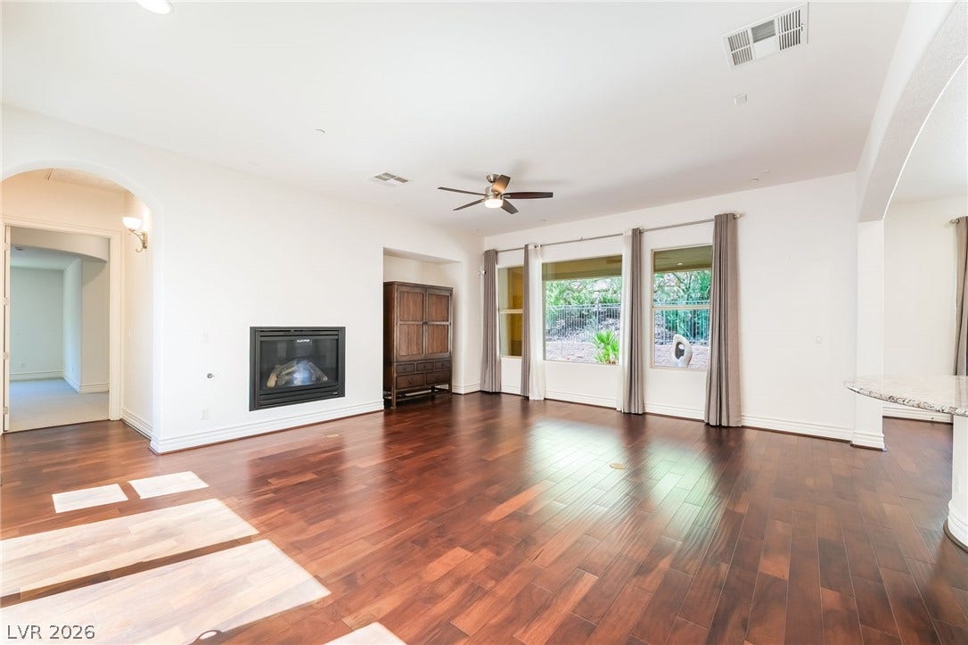 72 Rezzonico Drive, Henderson, NV 89011 Rich hardwood floors and a modern fireplace anchor this spacious living area with outdoor views.