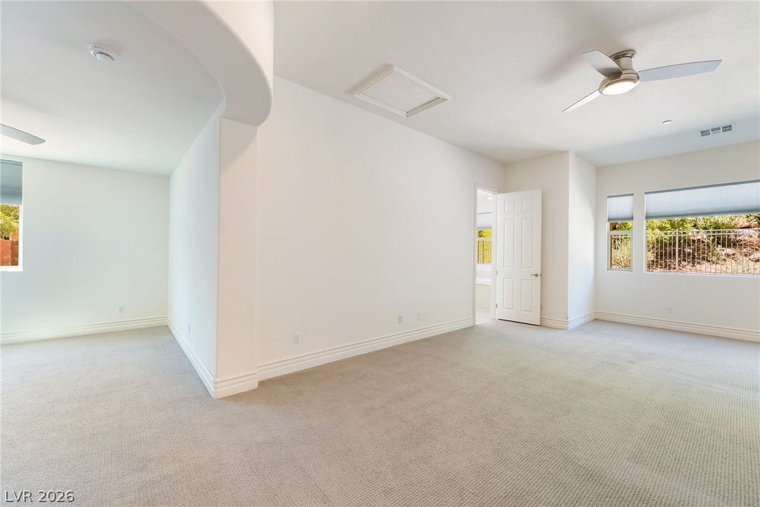 72 Rezzonico Drive, Henderson, NV 89011 Crisp white walls and plush carpeting define this spacious bedroom area.