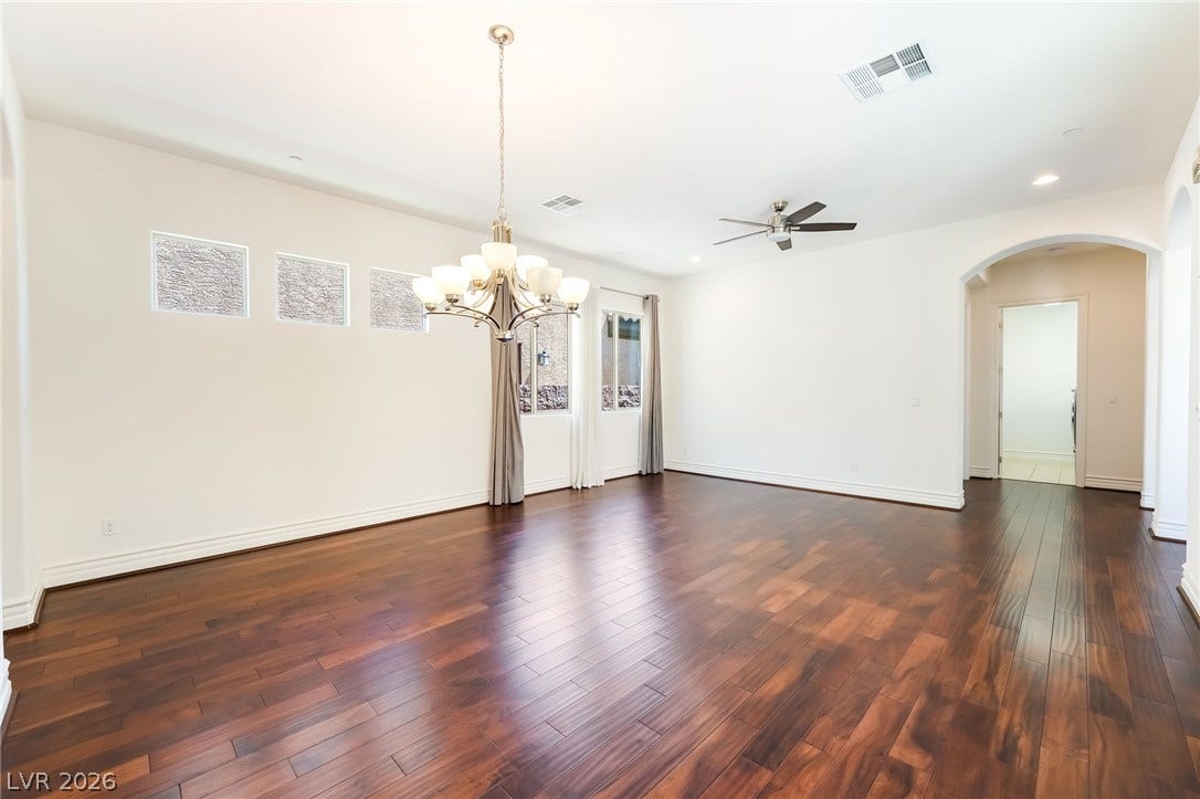 72 Rezzonico Drive, Henderson, NV 89011 Rich hardwood flooring runs throughout this open dining room featuring high ceilings and custom window details.