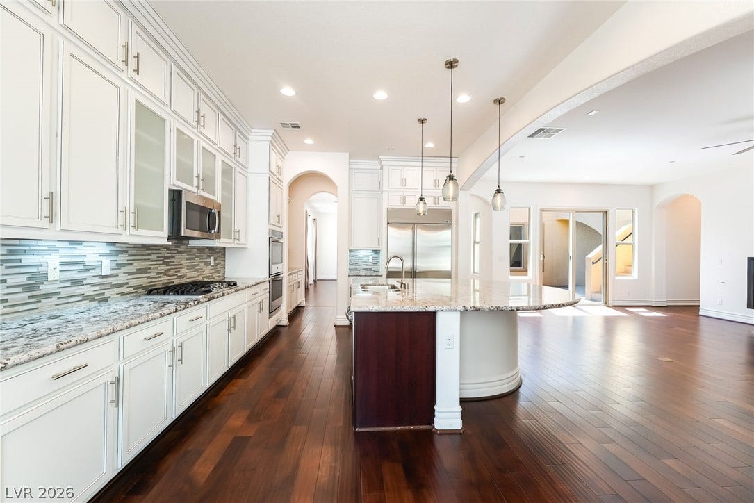 72 Rezzonico Drive, Henderson, NV 89011 Rich hardwood floors anchor this open culinary space featuring stone countertops and integrated appliances.