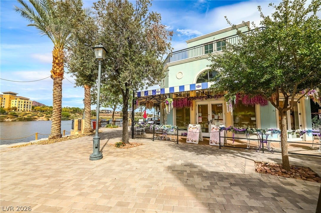 72 Rezzonico Drive, Henderson, NV 89011 Paved pathways wind along the waterfront near local shops and shade trees.