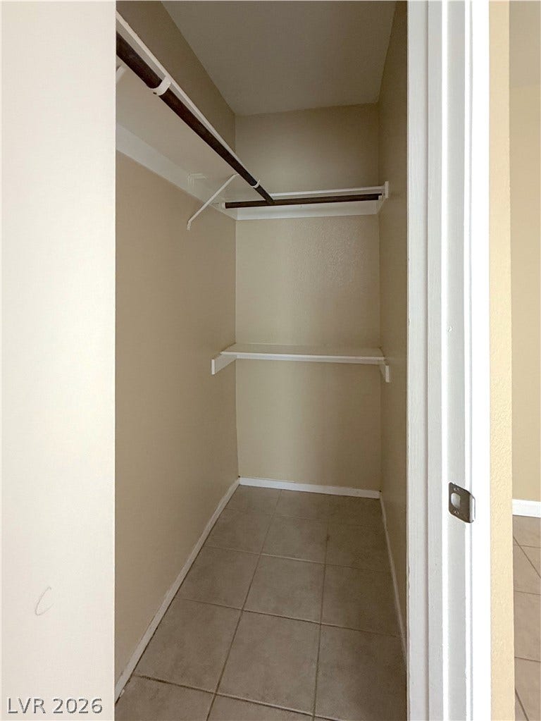 601 Avon Avenue, Henderson, NV 89014 A functional walk-in closet includes built-in shelving, hanging rods, and tiled flooring.