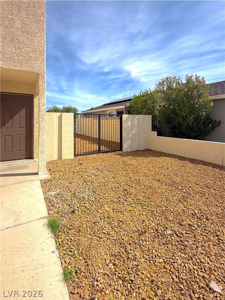 601 Avon Avenue, Henderson, NV 89014 Low-maintenance gravel landscaping and a secure gated entry define this functional outdoor space.
