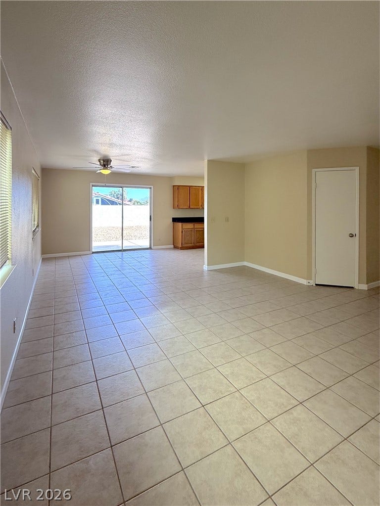 601 Avon Avenue, Henderson, NV 89014 Tiled flooring flows through an open-concept living space leading to a glass slider.