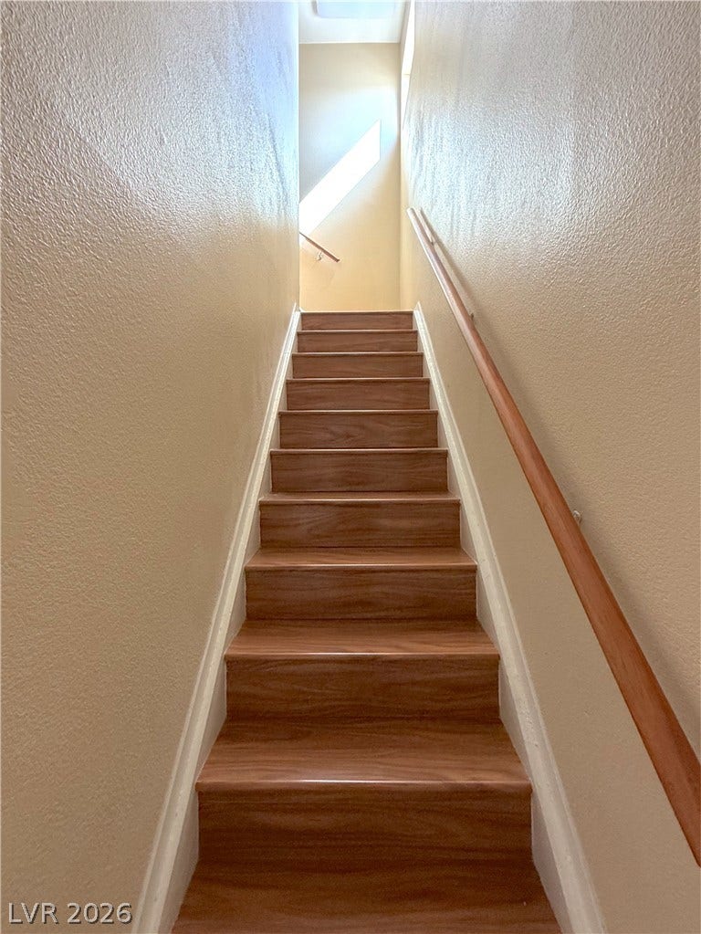 601 Avon Avenue, Henderson, NV 89014 Smooth wood treads guide the way upward beneath a towering, light-filled stairwell.