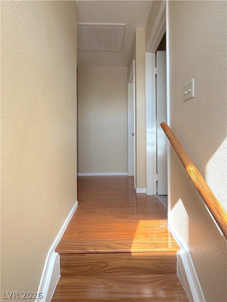 601 Avon Avenue, Henderson, NV 89014 Warm wood flooring and textured walls define this neutral transition space near the upper landing.