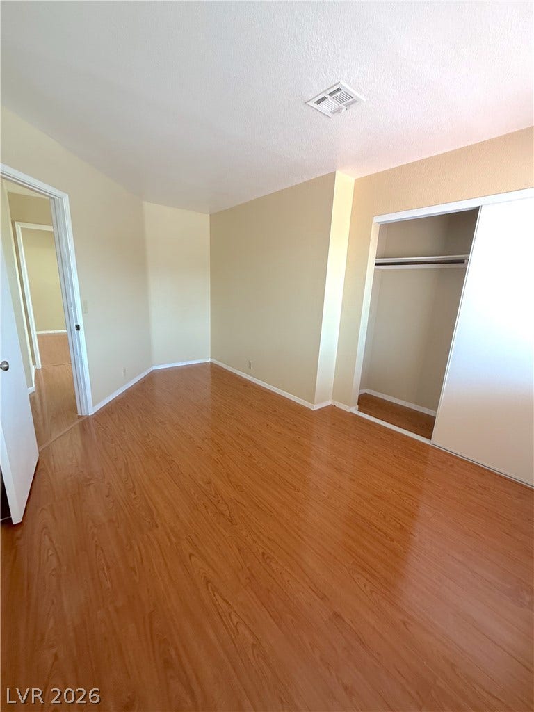 601 Avon Avenue, Henderson, NV 89014 Polished wood-plank flooring runs throughout this versatile bedroom with a built-in closet.