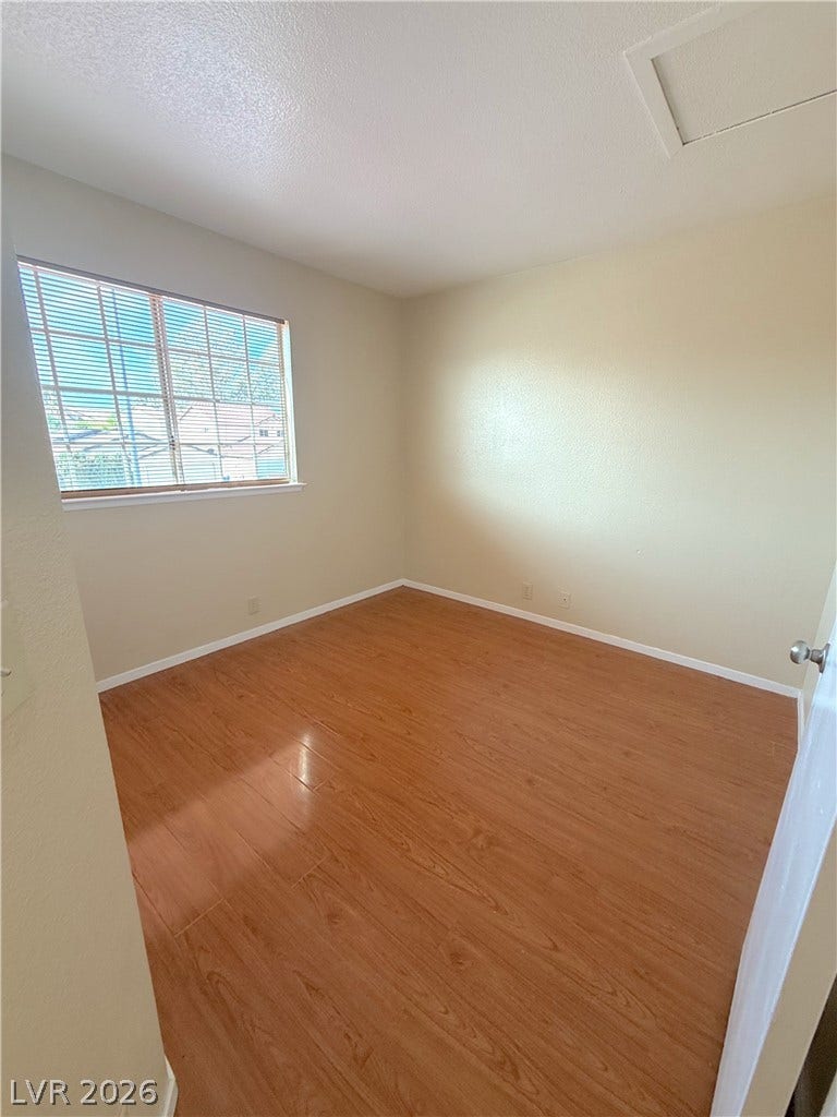 601 Avon Avenue, Henderson, NV 89014 Smooth wood floors and structured crown molding frame this versatile bedroom space.