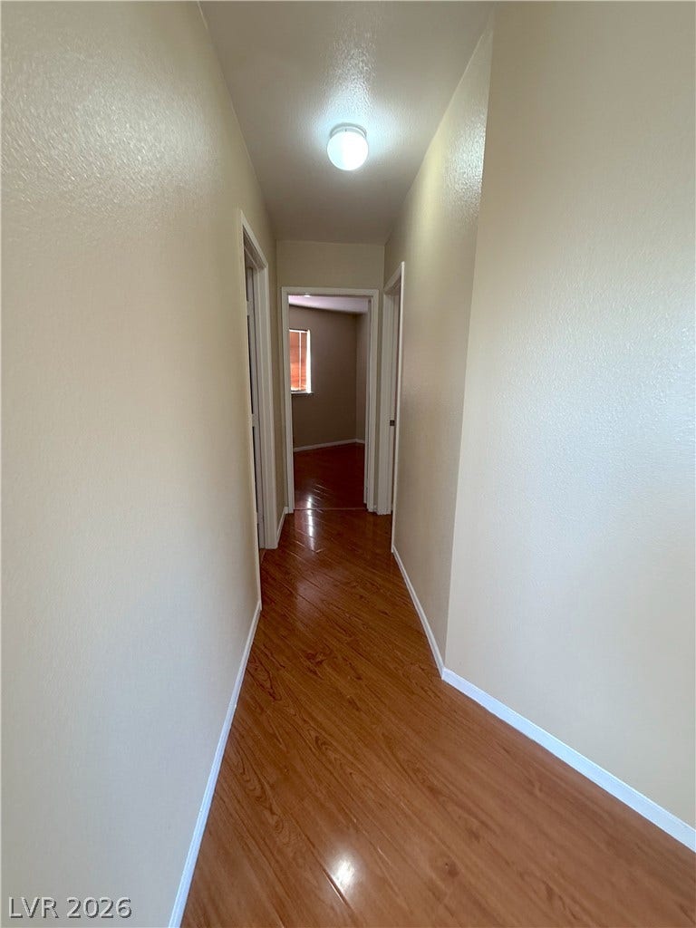 601 Avon Avenue, Henderson, NV 89014 Polished wood floors stretch through a neutral-toned hallway leading to adjacent rooms.