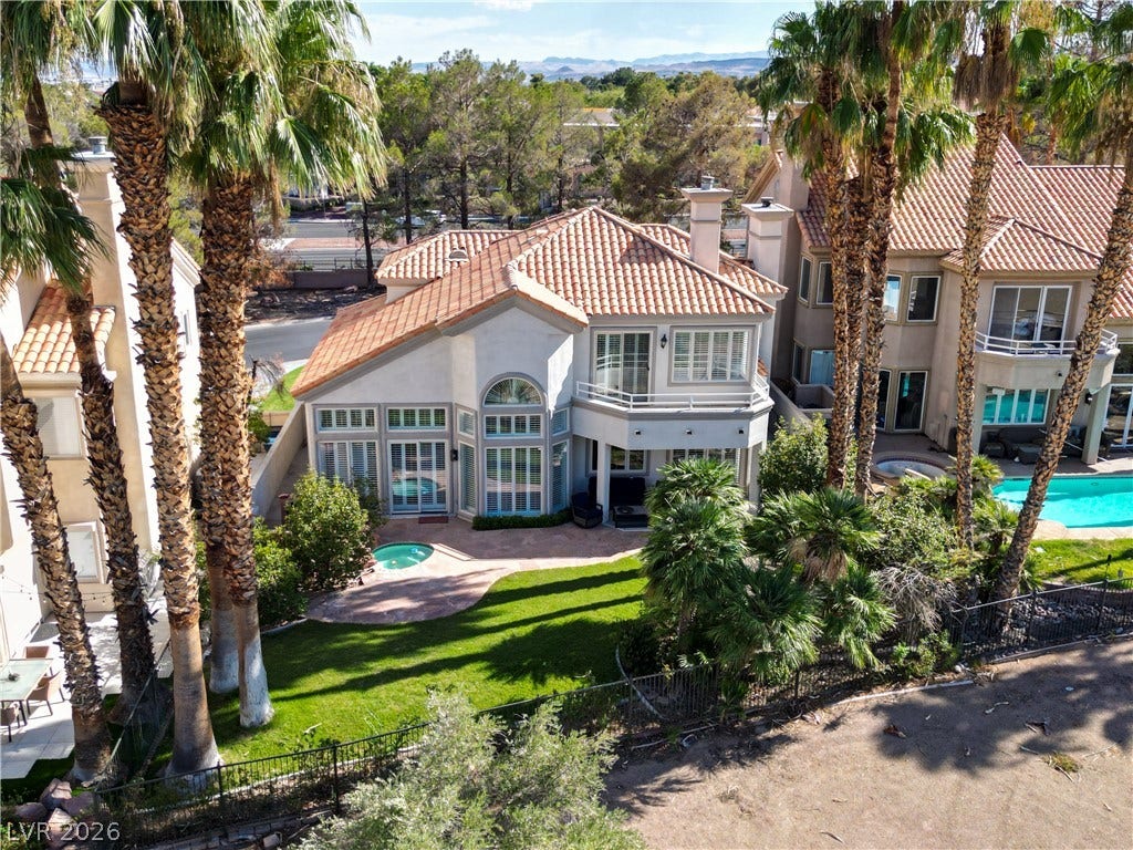 8848 Rainbow Ridge Drive, Las Vegas, NV 89117 Mediterranean-inspired architecture highlights this multi-level exterior nestled among mature palms.