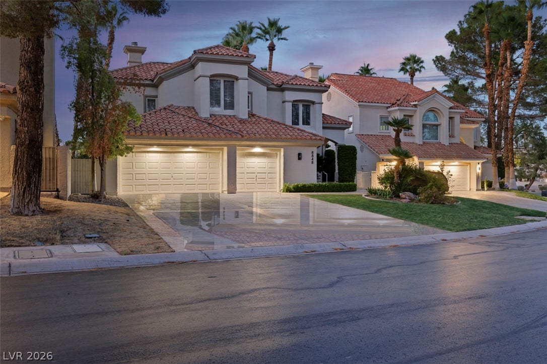 8848 Rainbow Ridge Drive, Las Vegas, NV 89117 Mediterranean style architecture shines under twilight skies.
