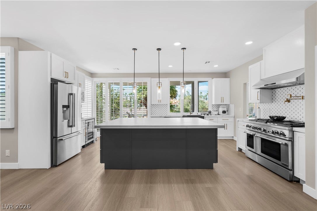 8848 Rainbow Ridge Drive, Las Vegas, NV 89117 An expansive central island grounds this contemporary culinary space with sleek light wood flooring.