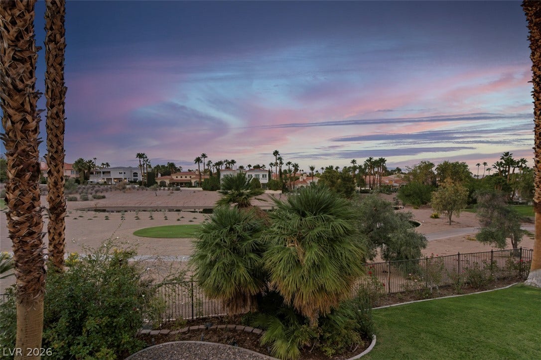 8848 Rainbow Ridge Drive, Las Vegas, NV 89117 Palm trees frame sweeping views of the surrounding neighborhood and golf course green under evening skies.