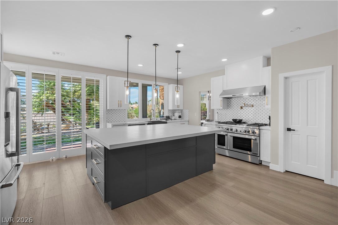 8848 Rainbow Ridge Drive, Las Vegas, NV 89117 An expansive central island grounds this contemporary culinary space anchored by warm wood-toned flooring.